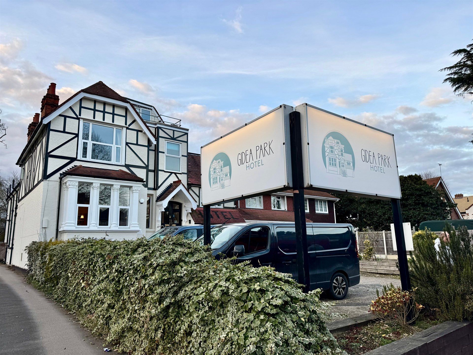 A large house with a van parked in front of it.