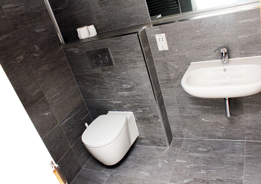 A bathroom with a toilet a sink and a mirror