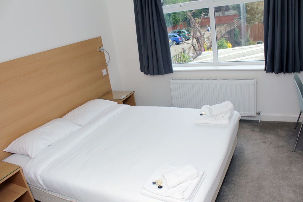 A hotel room with a large bed and a window