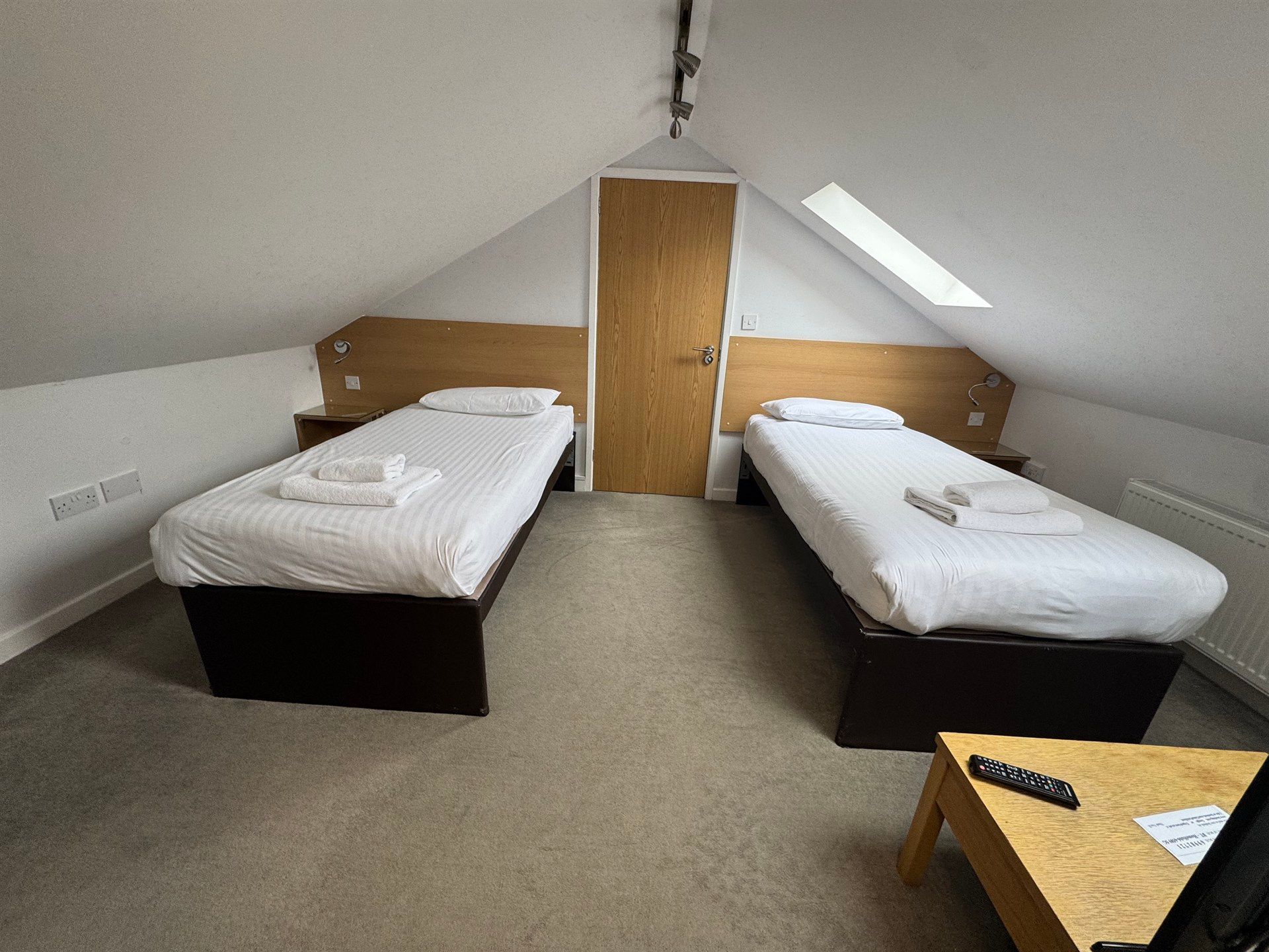 A bedroom with two beds , a table and a television.