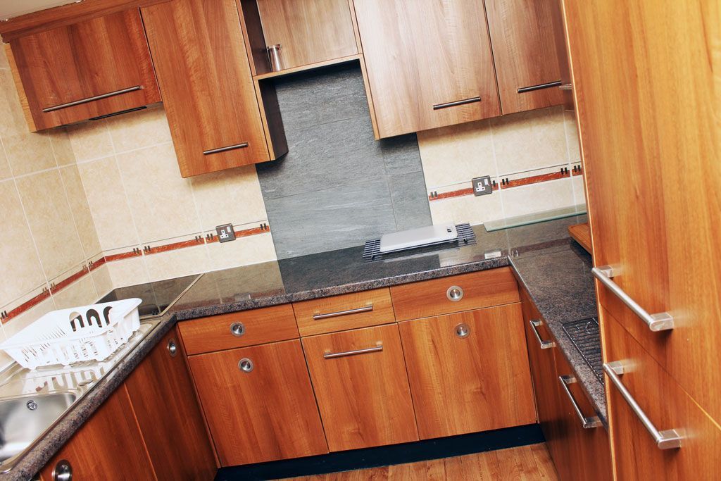 A kitchen with wooden cabinets and granite counter tops