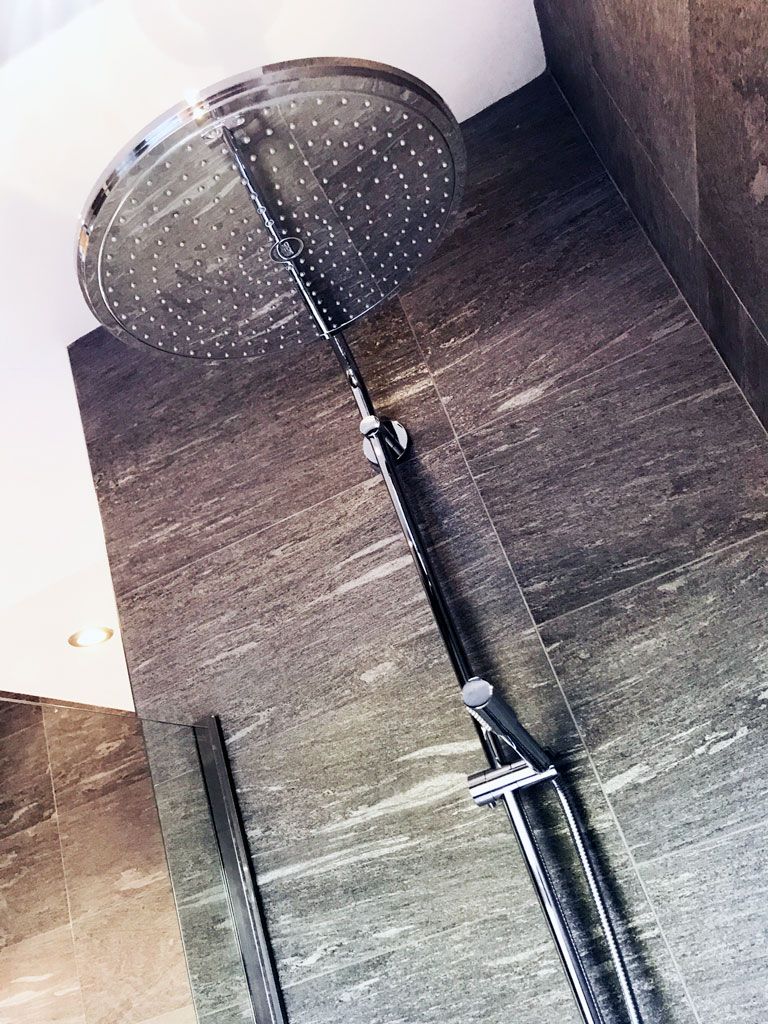 A close up of a shower head in a bathroom.