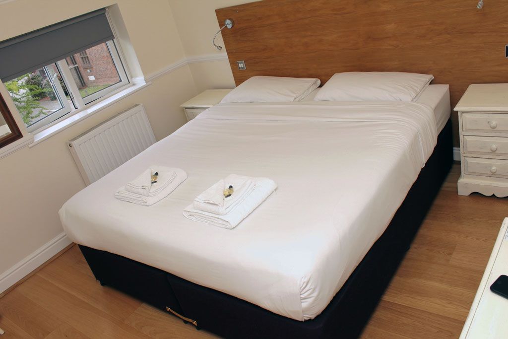 A hotel room with a bed and two nightstands