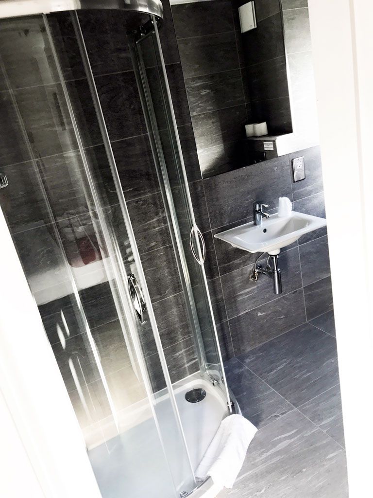 A bathroom with a sink , shower , and mirror.