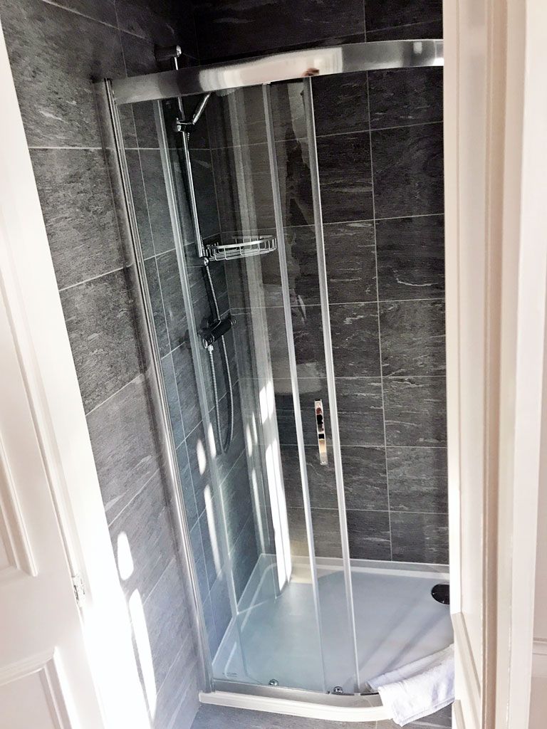 A shower stall with a sliding glass door in a bathroom.