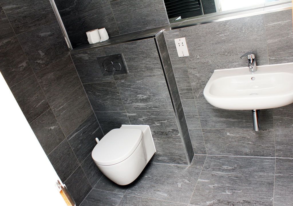 A bathroom with a toilet a sink and a mirror