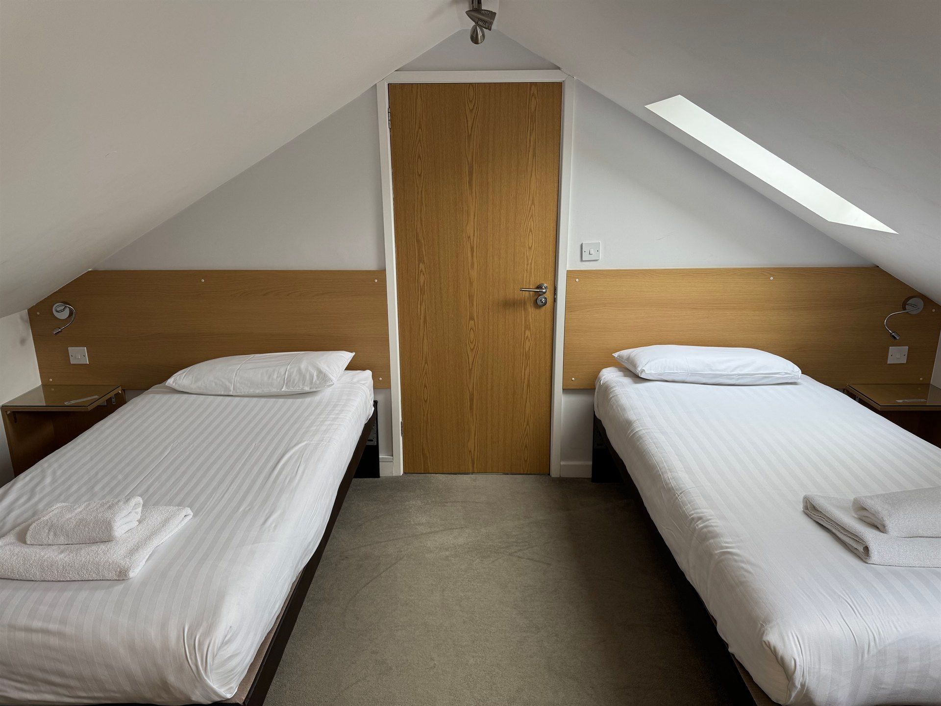 A bedroom with two twin beds and a door.