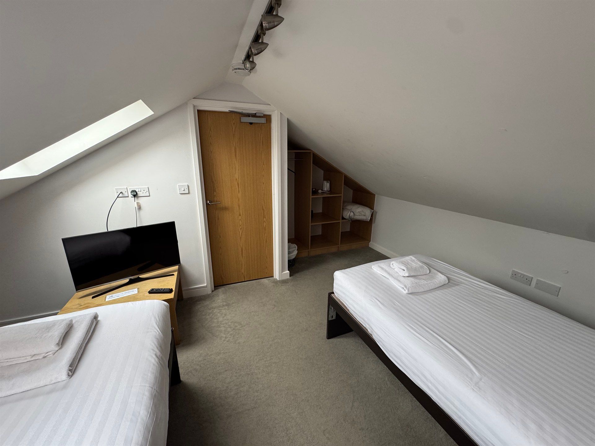 A bedroom with two beds and a flat screen tv