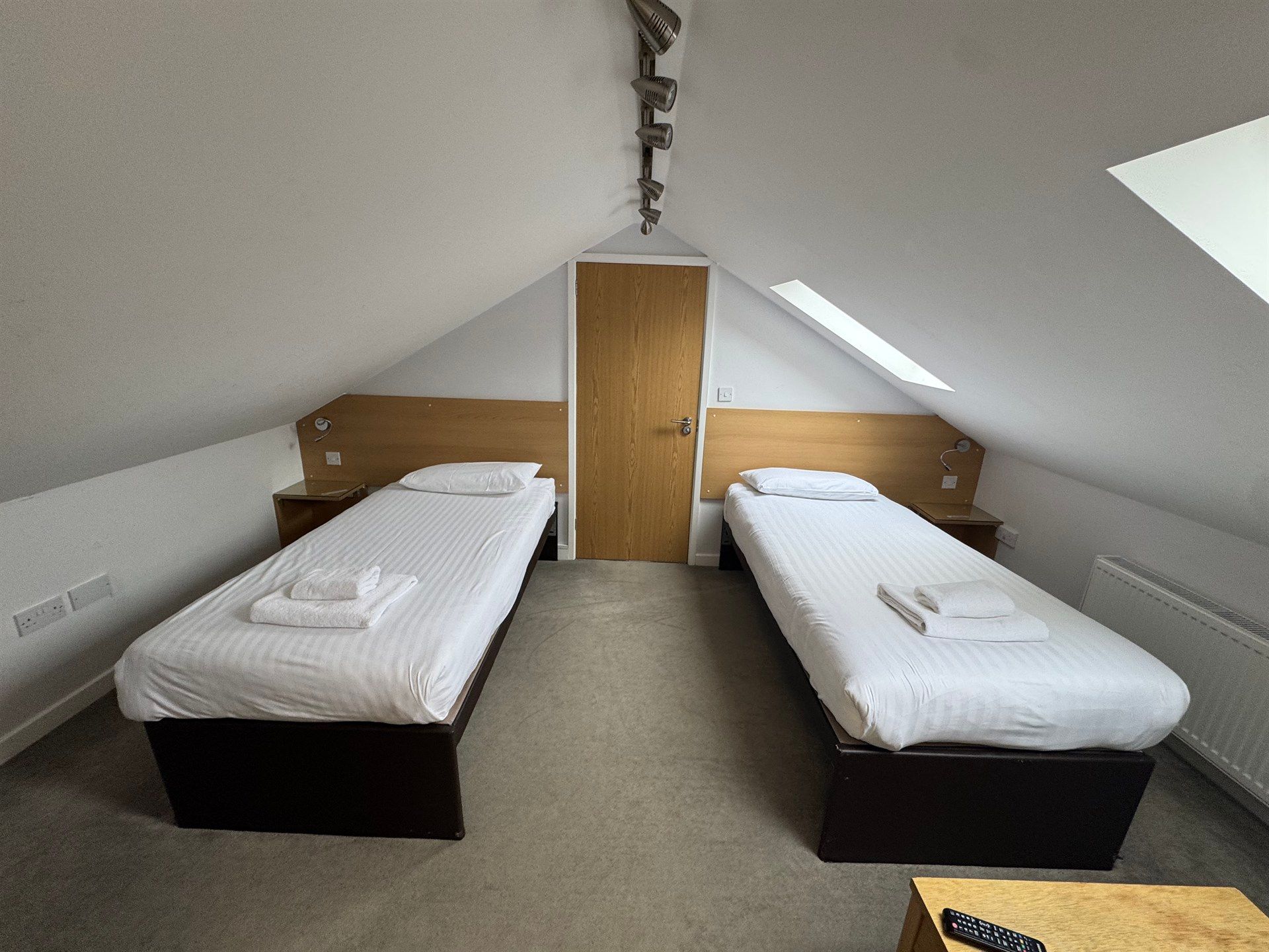 A bedroom with two twin beds and a ceiling fan.