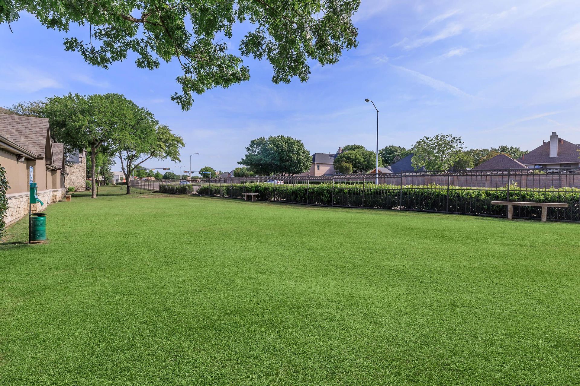 A large lush green field with a house in the background.