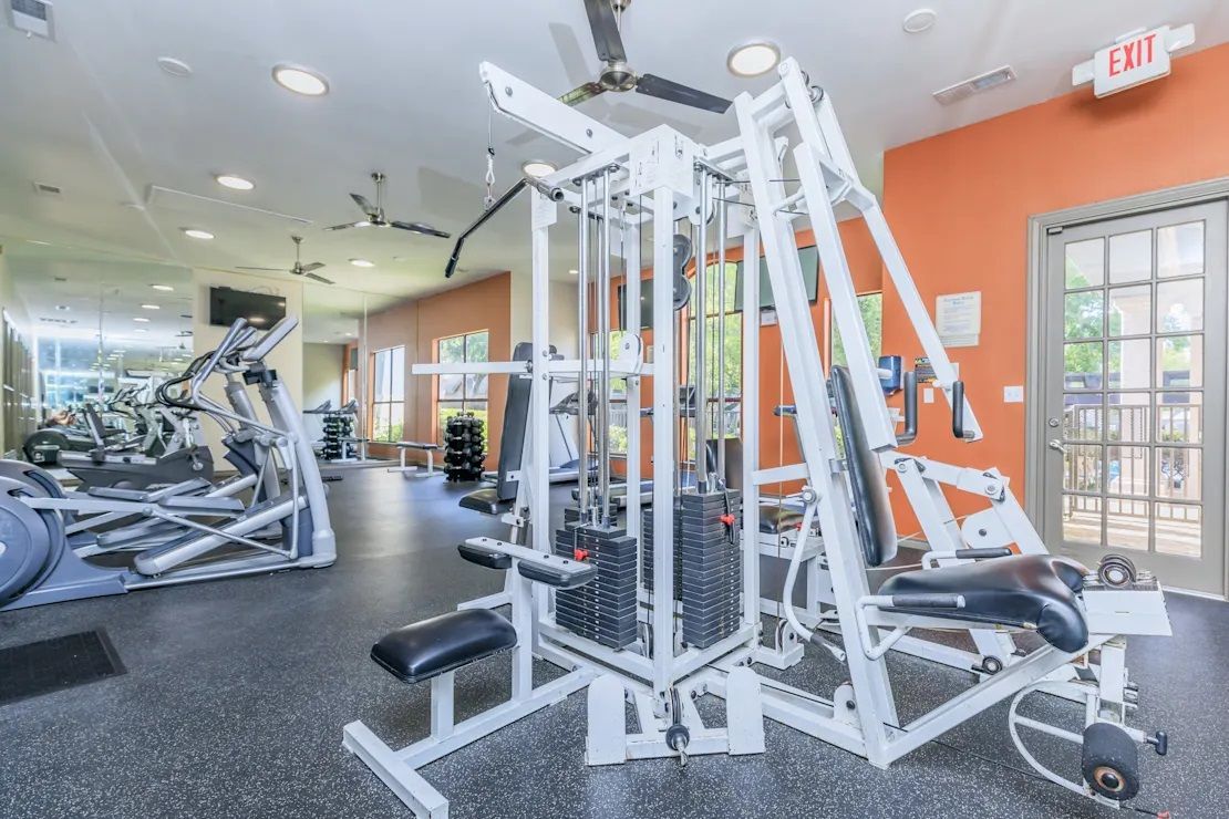 A large gym filled with lots of exercise equipment.