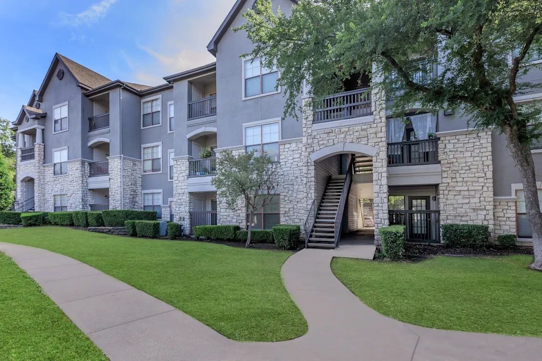 A large apartment building with a walkway leading to it.