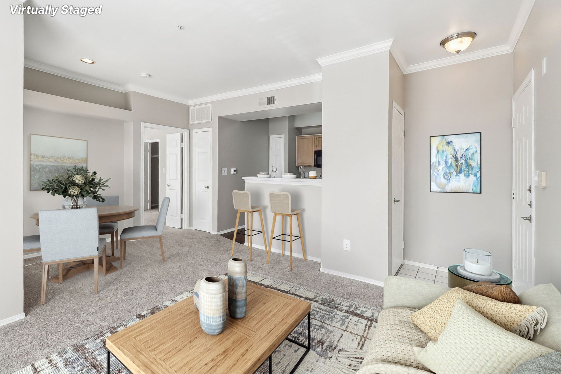 A living room with a couch , coffee table , dining table and chairs.