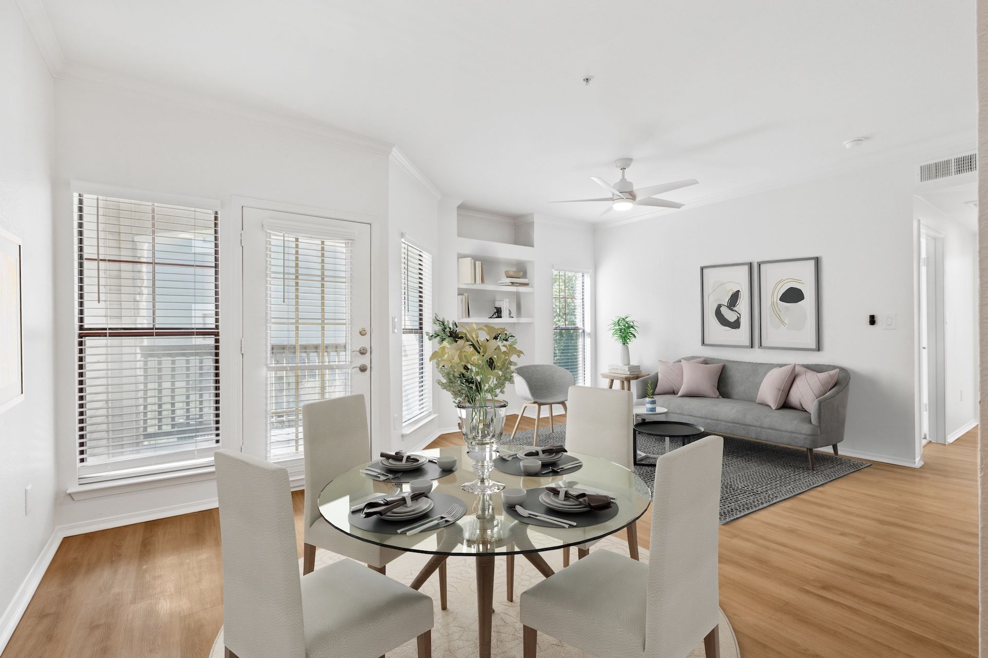 Dining room with glass table, four chairs, balcony access, and a sofa.