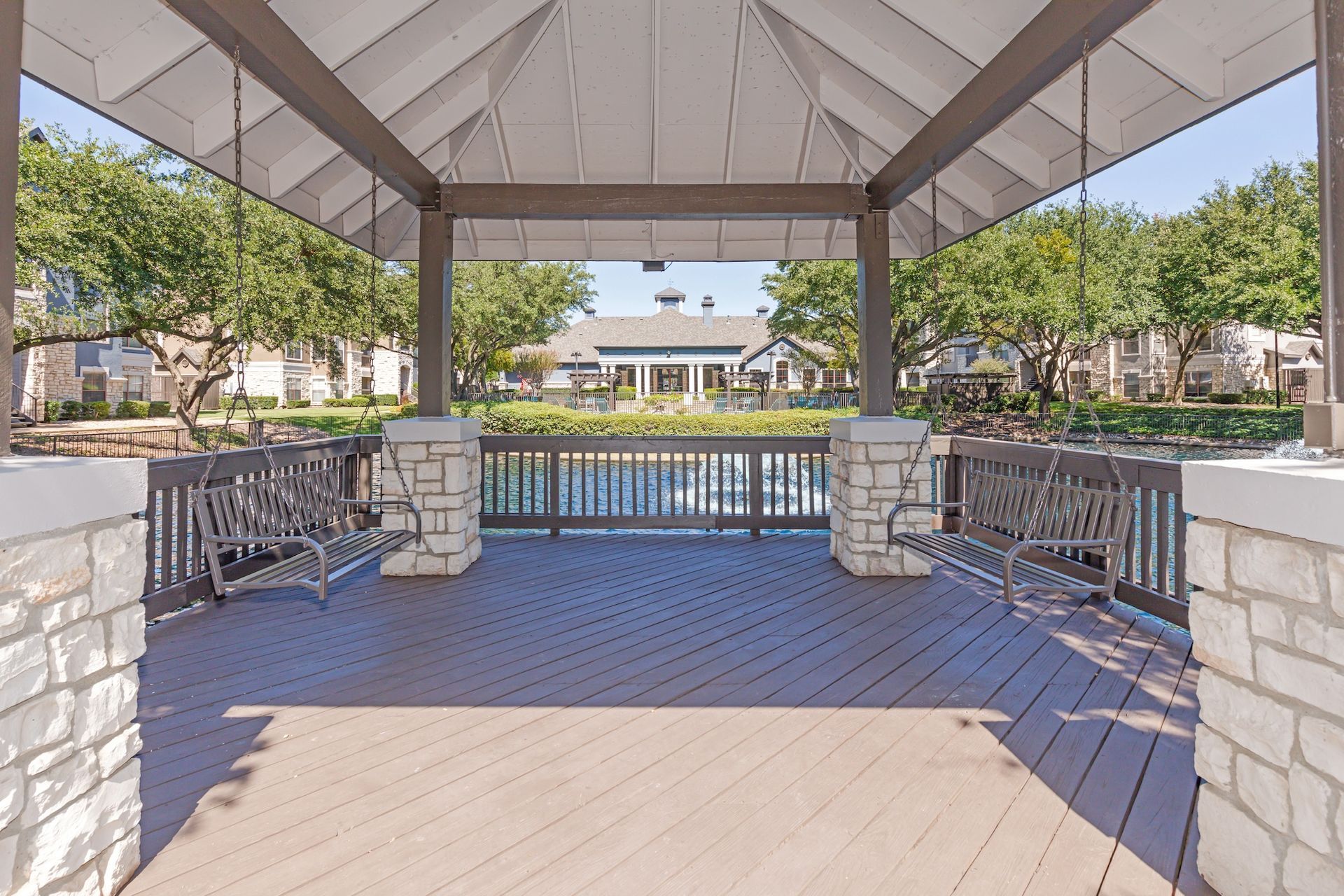 A gazebo with a view of a lake and a house in the background