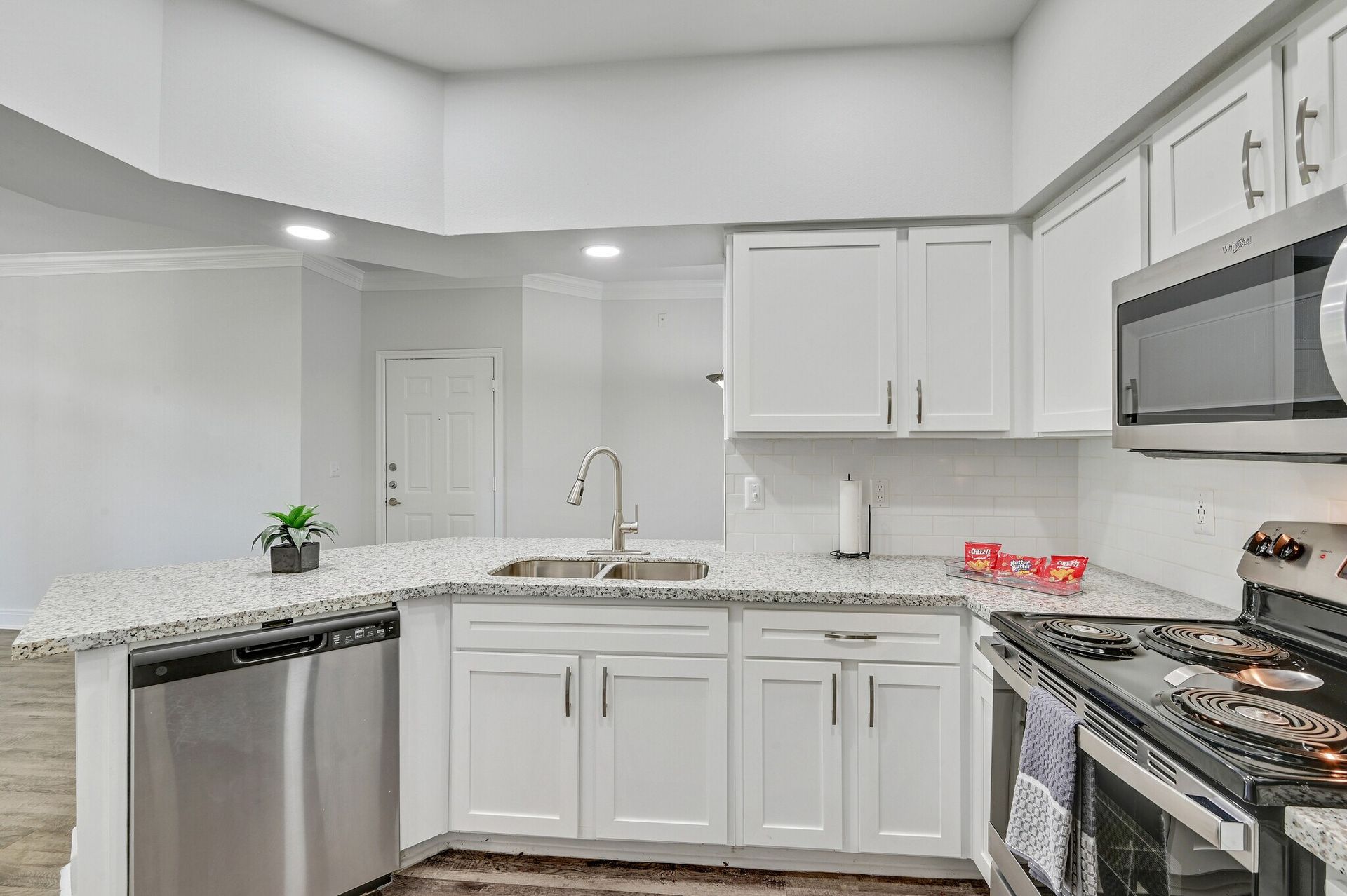 Kitchen with white cabinets, stainless steel appliances, and granite countertops.