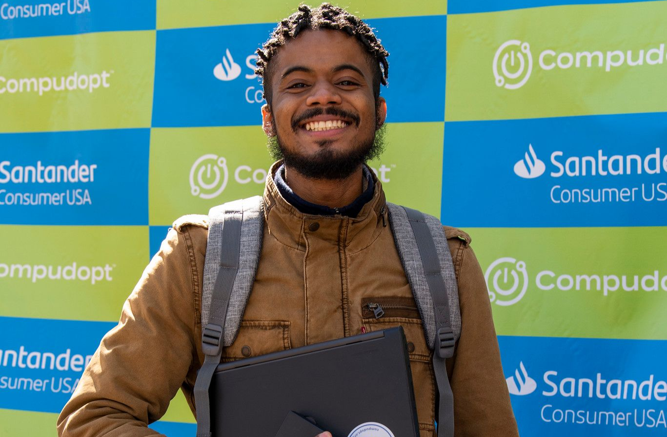 College-aged man holding a laptop