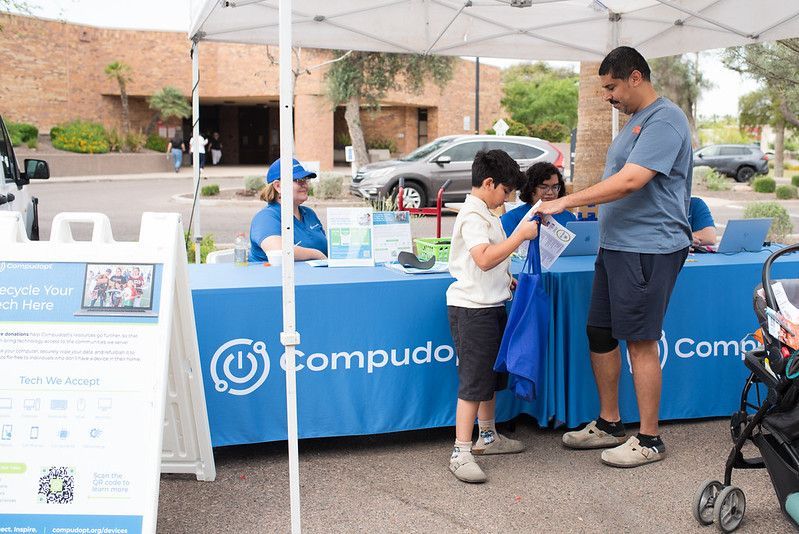 A Tempe family picks up their free computer from the Compudopt tent at the 8th Annual Care Fair Tempe.