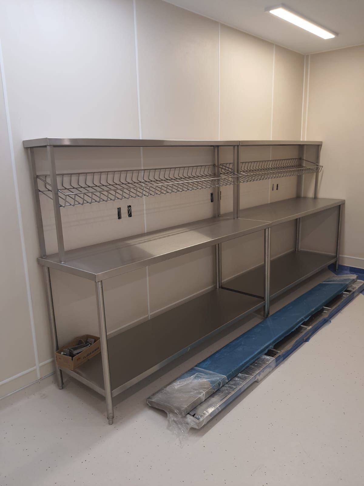 Una mesa de acero inoxidable con estantes en una habitación.