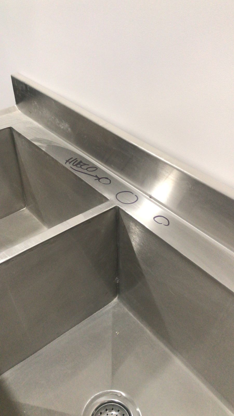 Un primer plano de un fregadero de acero inoxidable en una cocina.