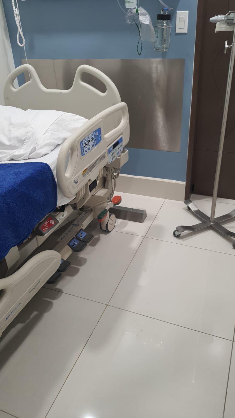 Una cama de hospital está sentada en el suelo de una habitación de hospital.