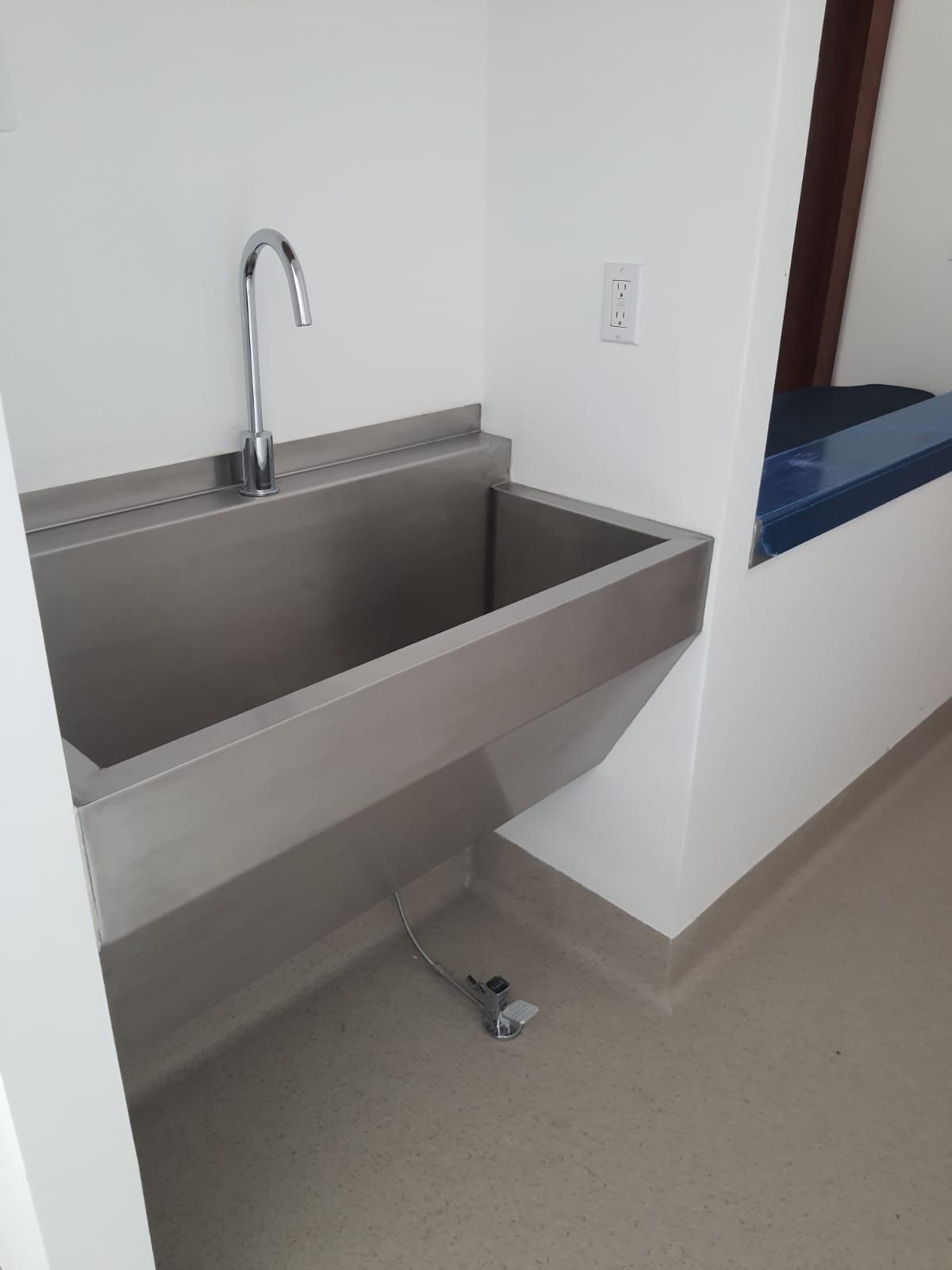 Un lavabo de acero inoxidable con grifo en el baño.