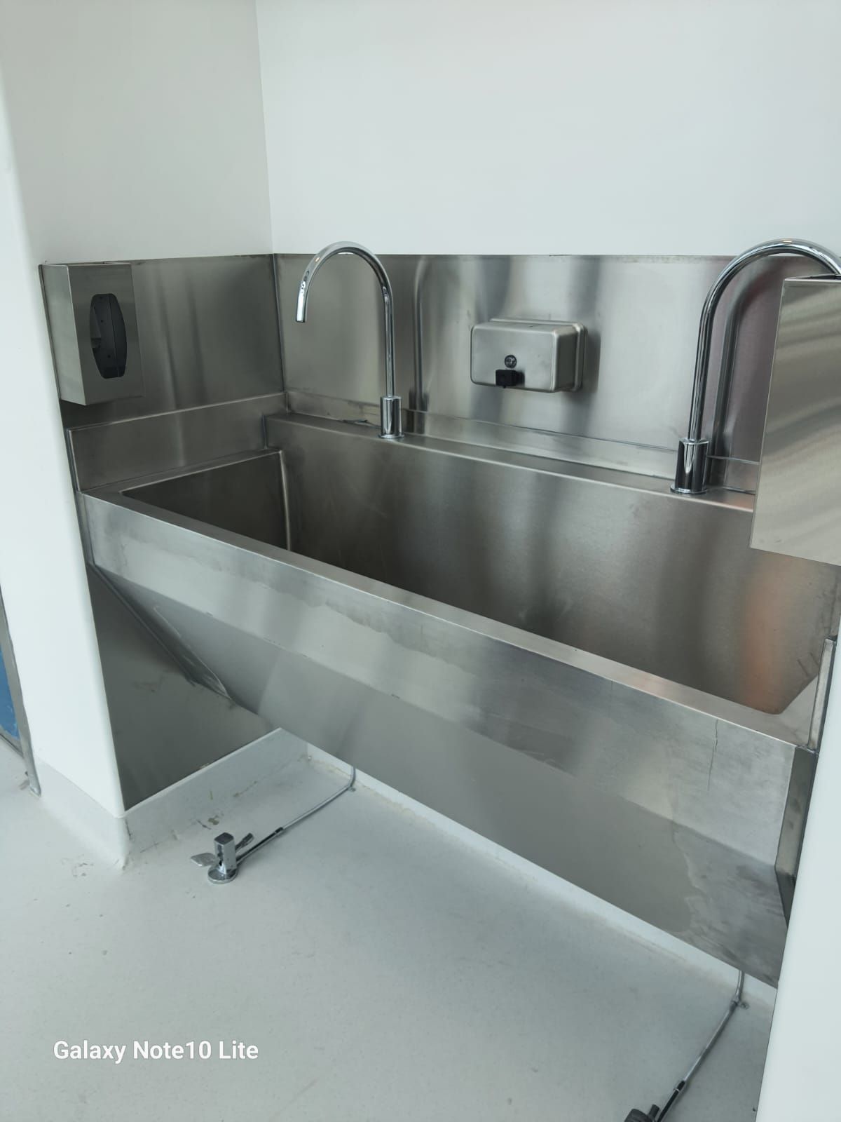 Un fregadero de acero inoxidable con dos grifos en una habitación.