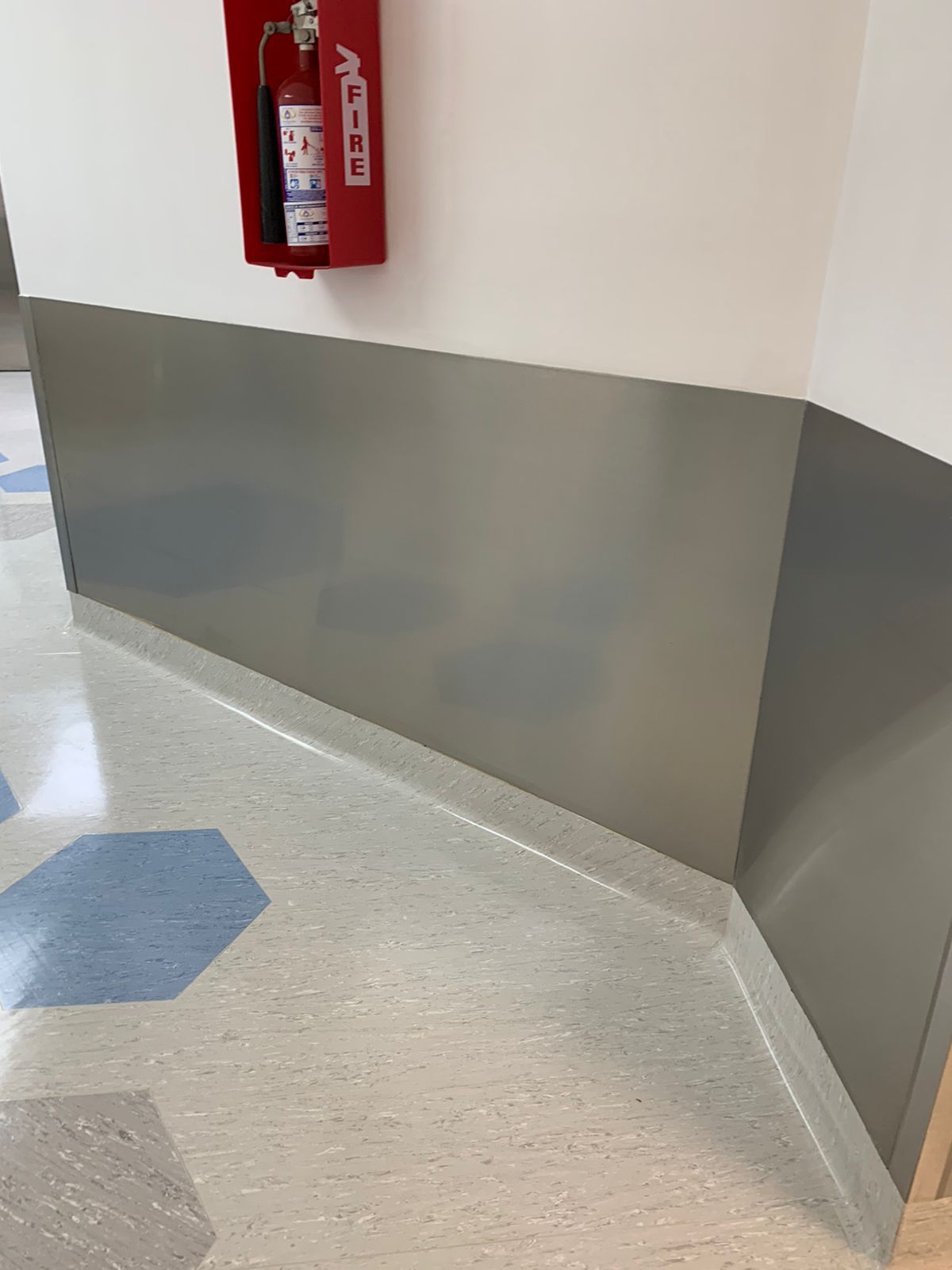 Un extintor de incendios está colgado en la pared de un pasillo.