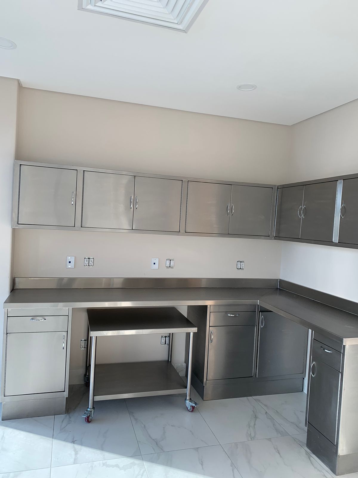 Una cocina con gabinetes de acero inoxidable y una mesa.