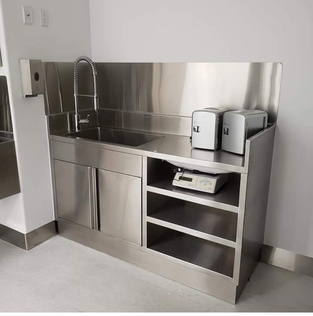 Una cocina con gabinetes de acero inoxidable y fregadero.