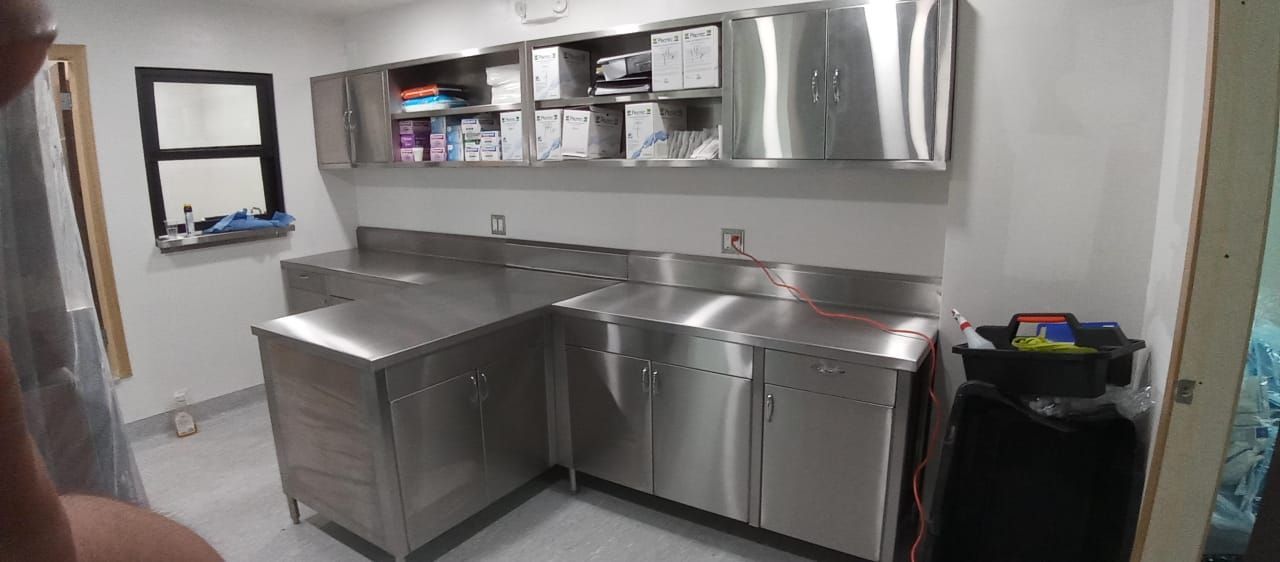 Una cocina con gabinetes de acero inoxidable y refrigerador.