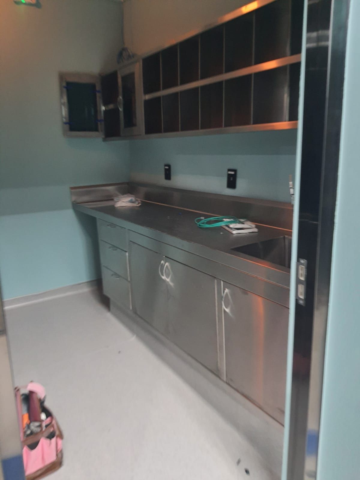 Una cocina con gabinetes y estantes de acero inoxidable.