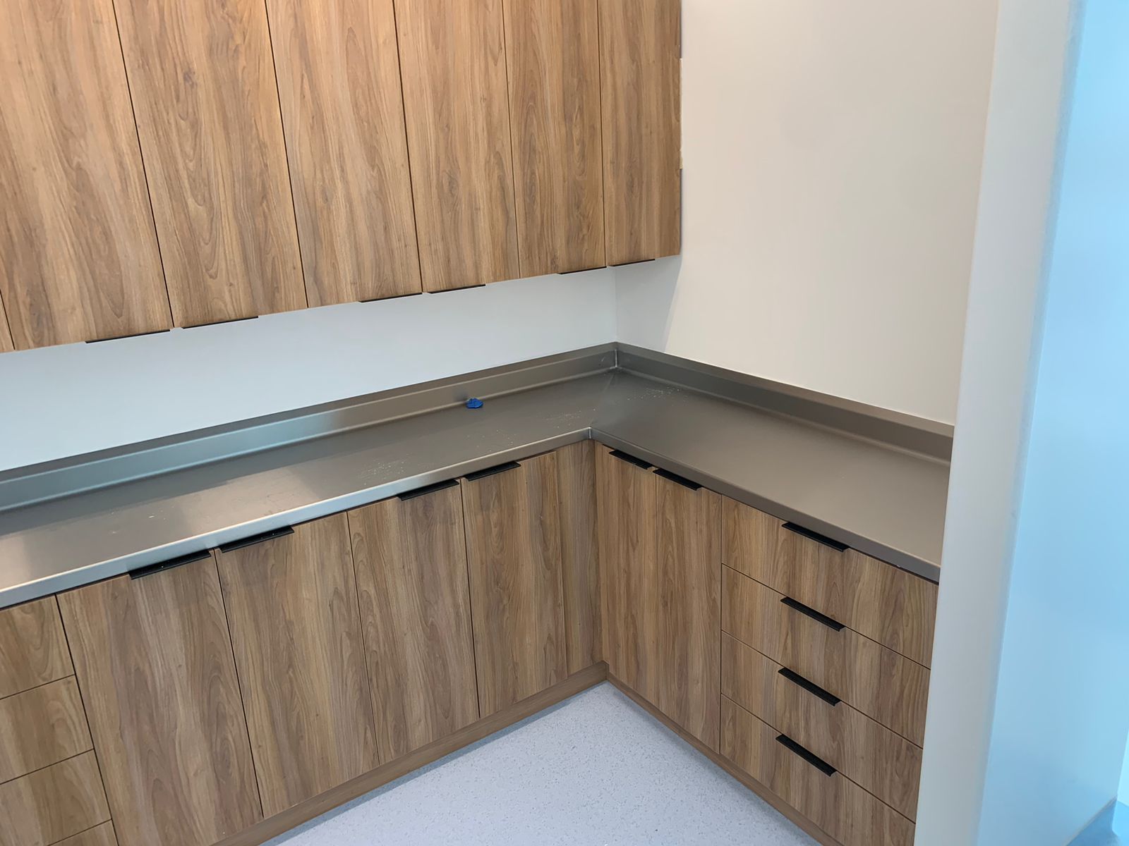 Una cocina con gabinetes de madera y encimera de acero inoxidable.