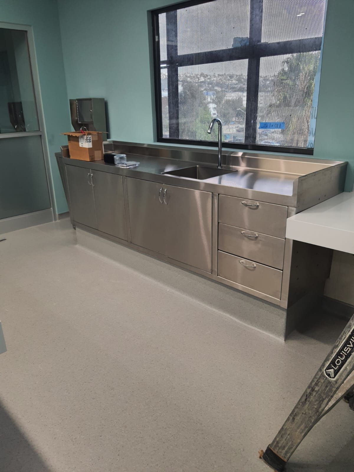 Una cocina con muebles de acero inoxidable y fregadero.