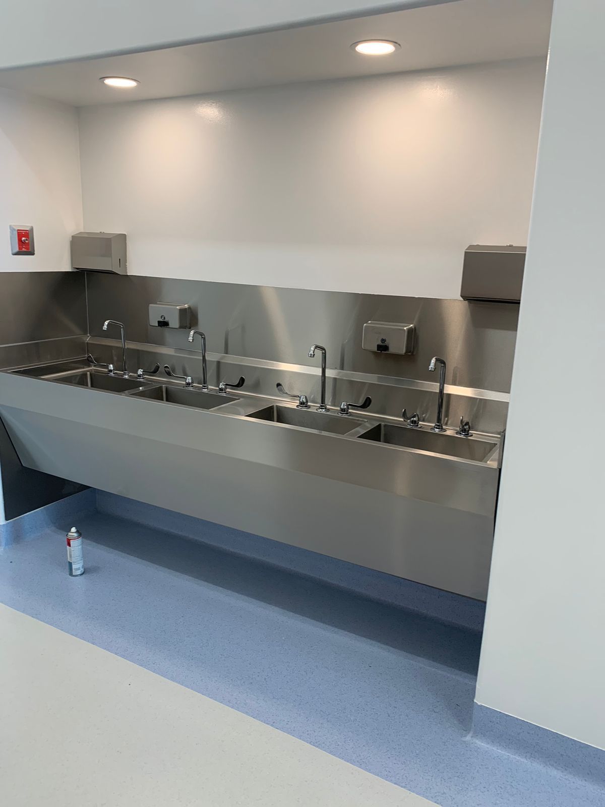 Una fila de fregaderos de acero inoxidable en una cocina.