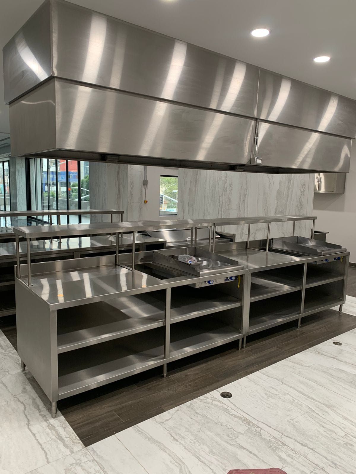 Una cocina con muchos electrodomésticos y estanterías de acero inoxidable.lip