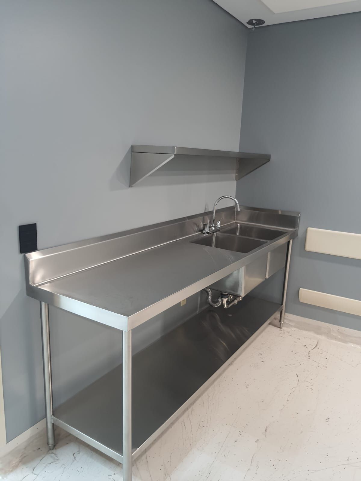 Una cocina con encimera y fregadero de acero inoxidable.