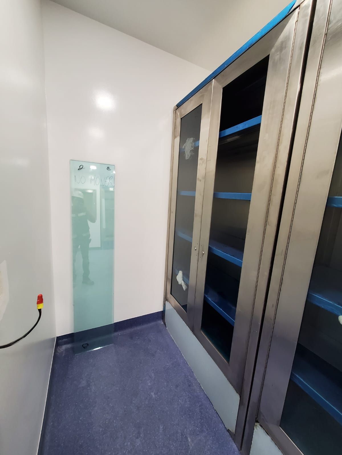 Una habitación con armarios de acero inoxidable y estanterías azules.