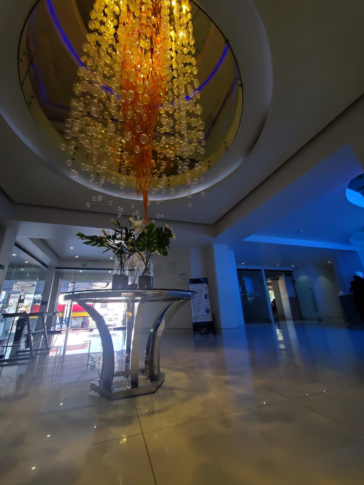 Una gran lámpara de araña cuelga del techo encima de una mesa.