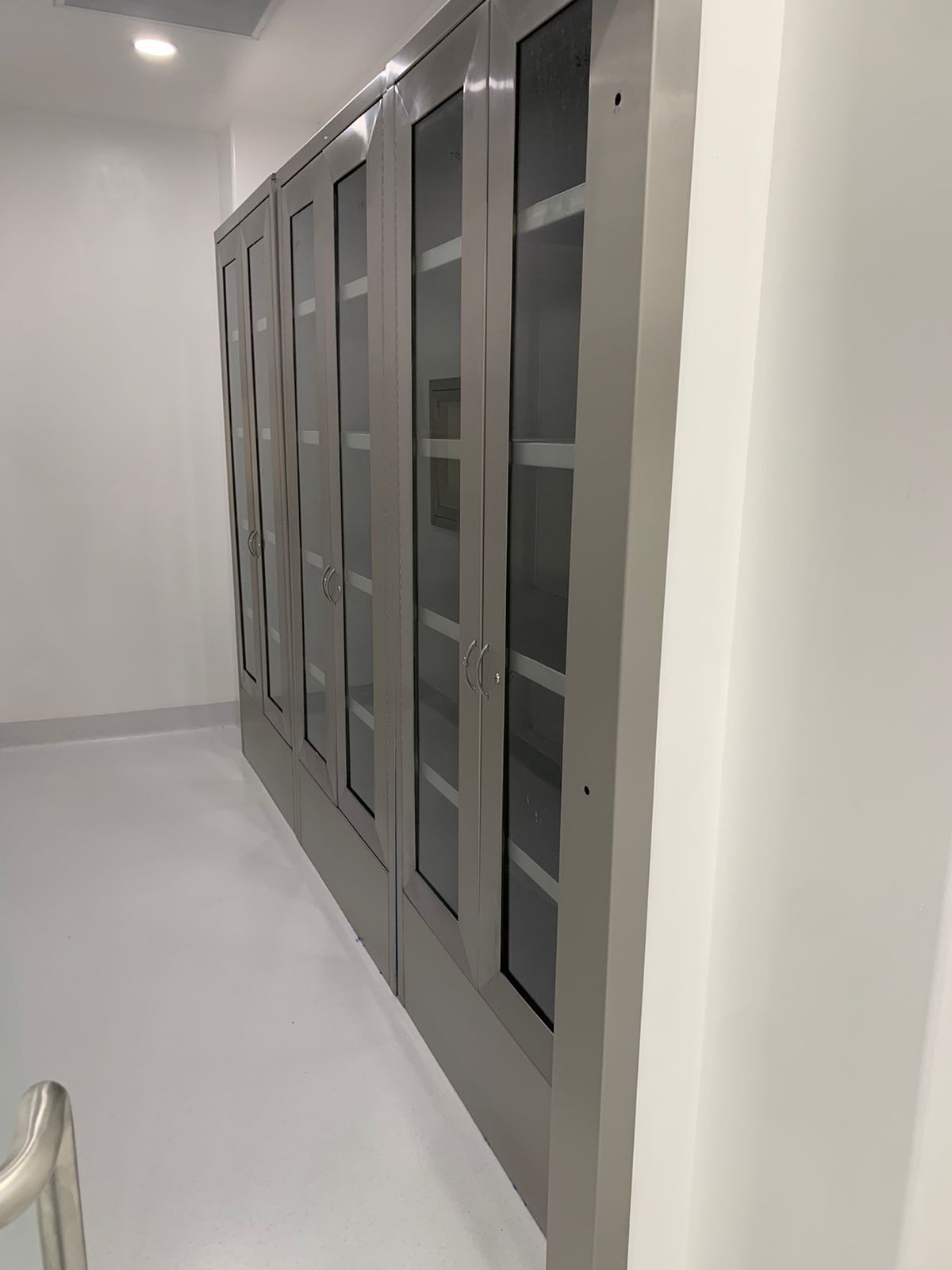 Una fila de armarios con puertas de cristal en una habitación.