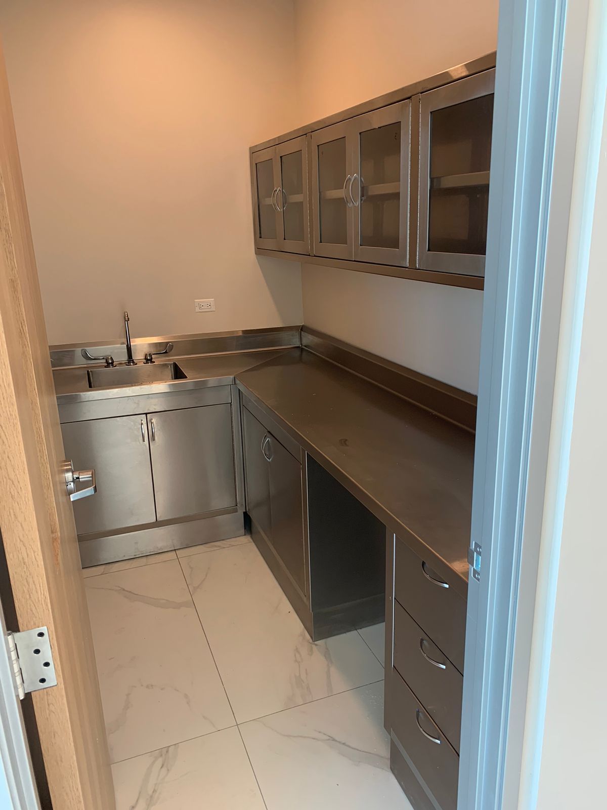 Una cocina con muebles de acero inoxidable y fregadero.