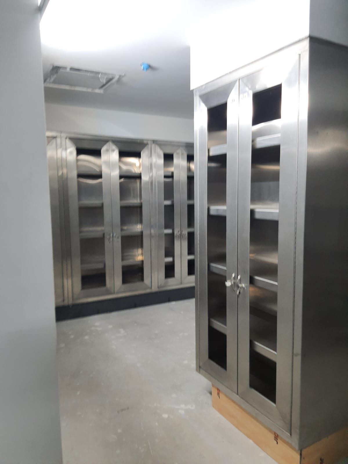 Una fila de gabinetes de acero inoxidable con puertas de vidrio.