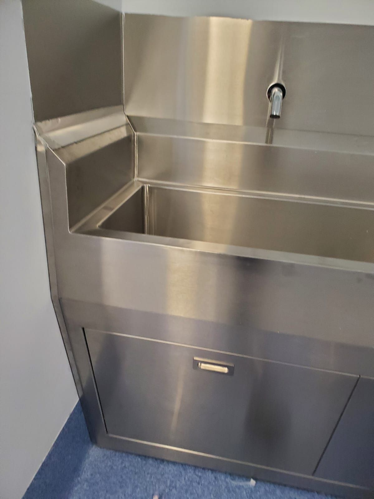 Un fregadero de acero inoxidable con grifo lateral.