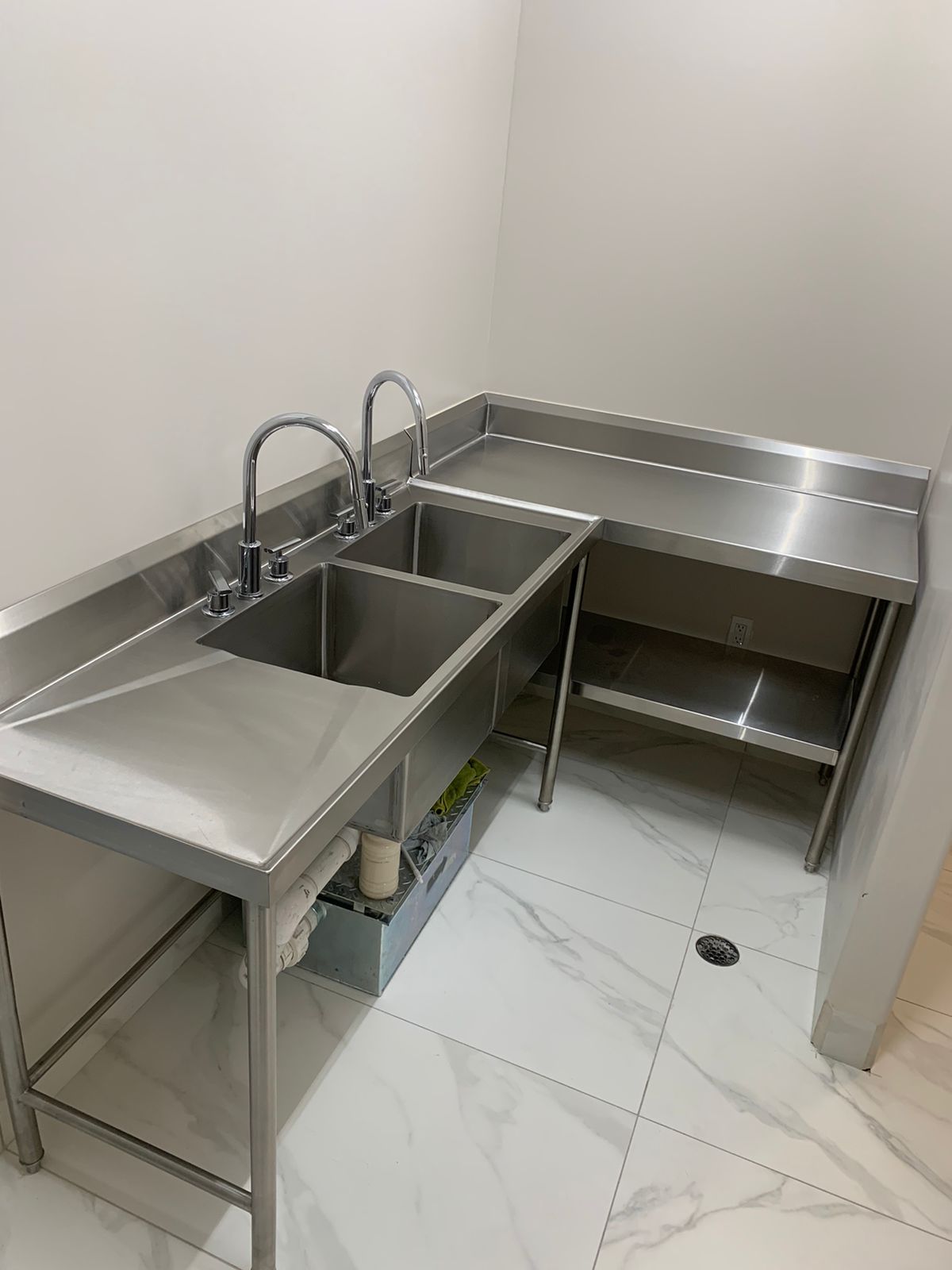 Una cocina con dos fregaderos y encimera de acero inoxidable.