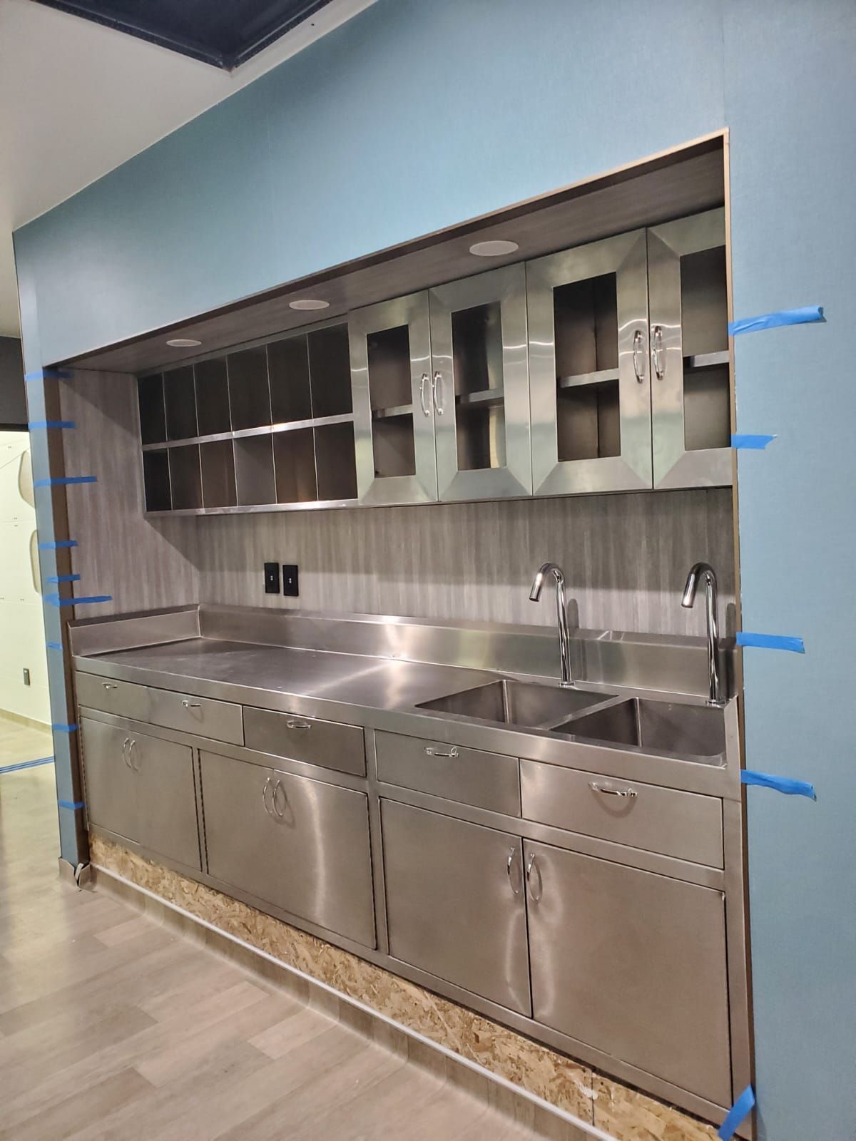 Una cocina con muebles y fregaderos de acero inoxidable.