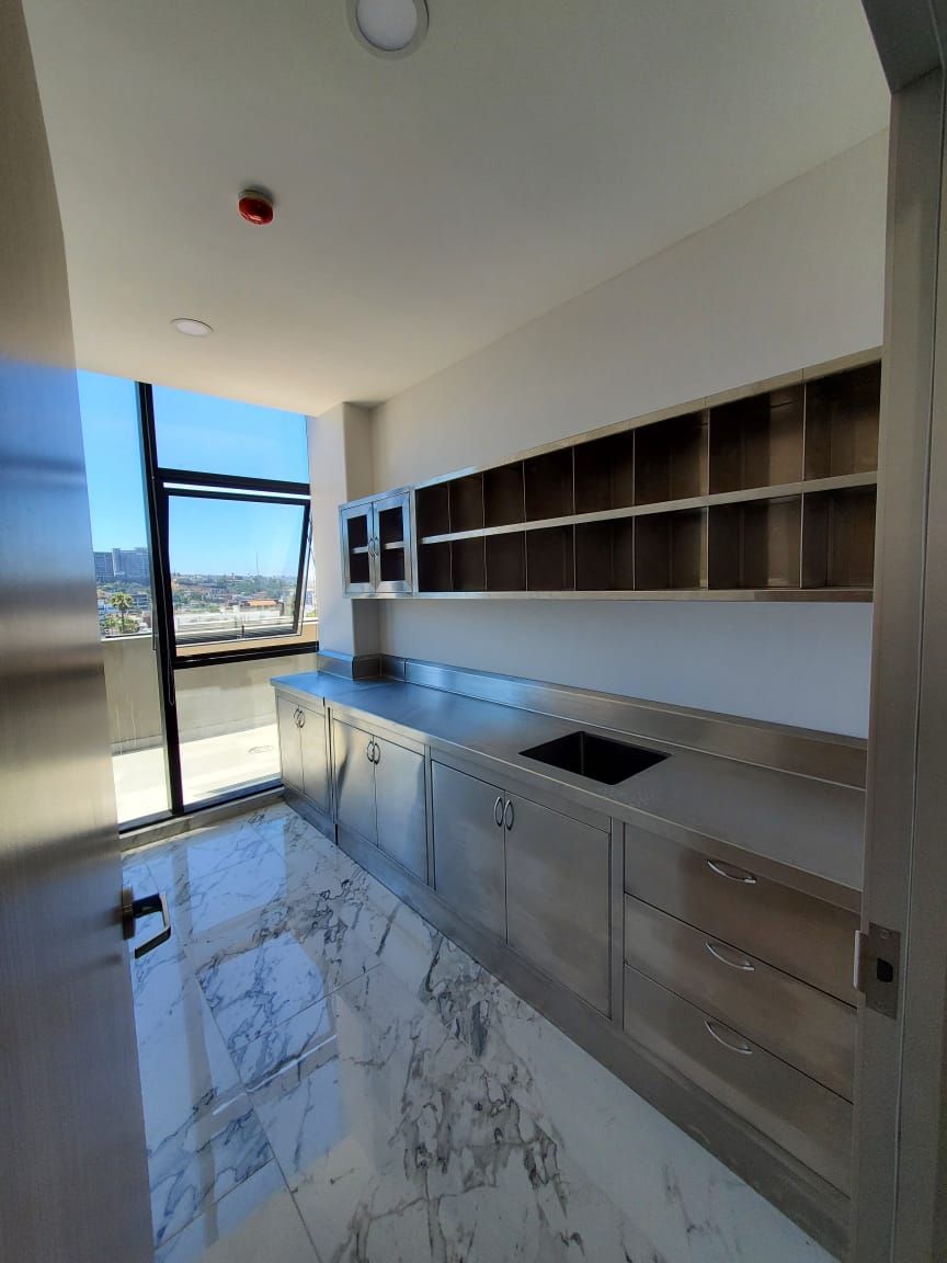 Una cocina con suelos de mármol y un gran ventanal.