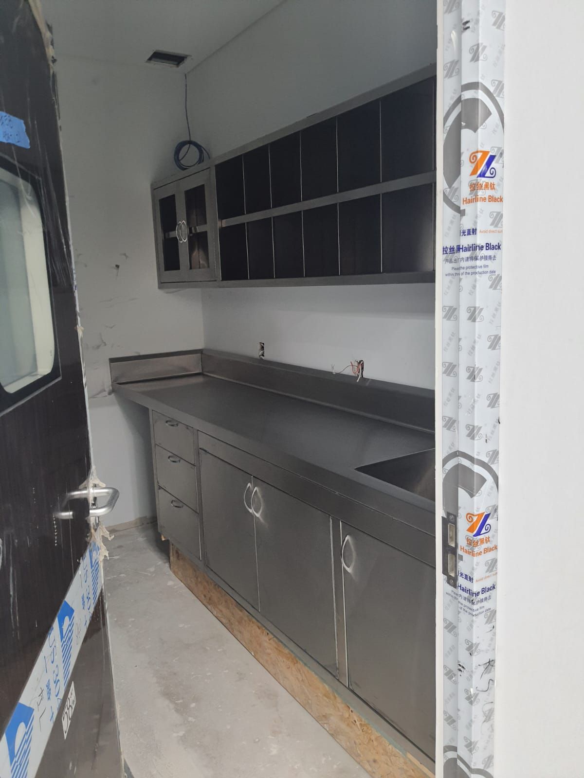 Una cocina con muebles de acero inoxidable y fregadero.