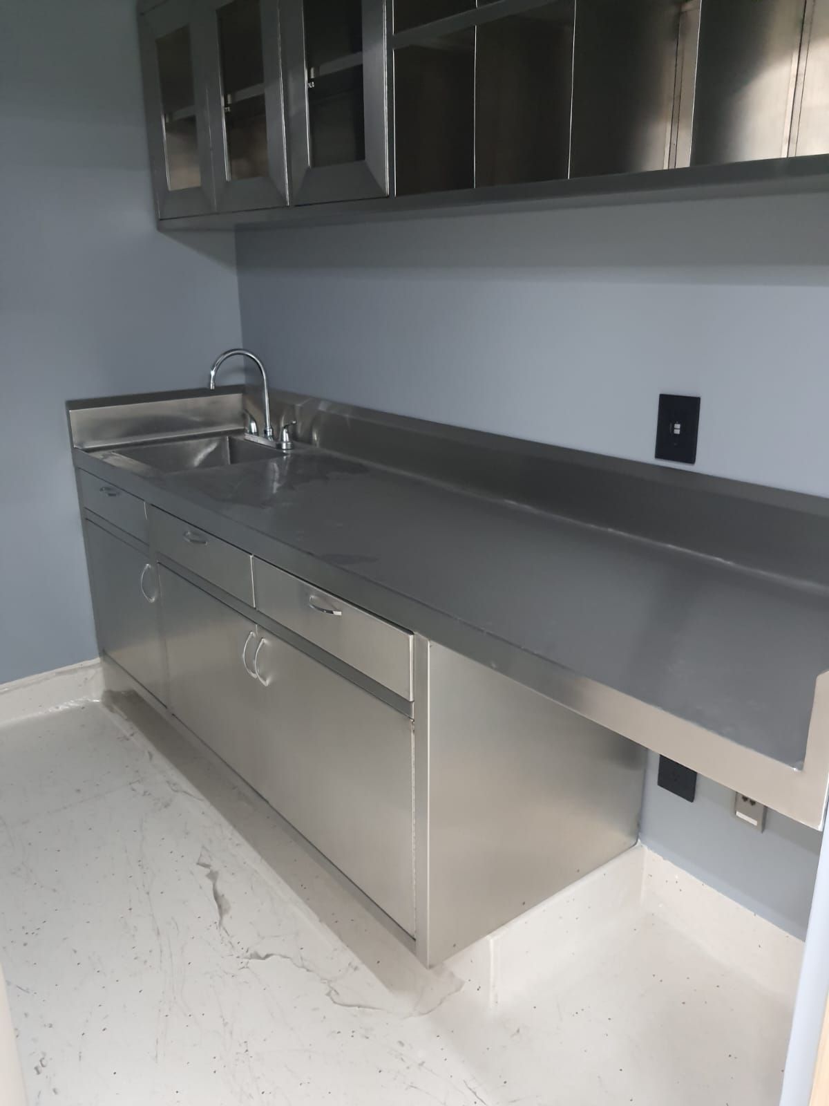 Una cocina con gabinetes de acero inoxidable y fregadero.