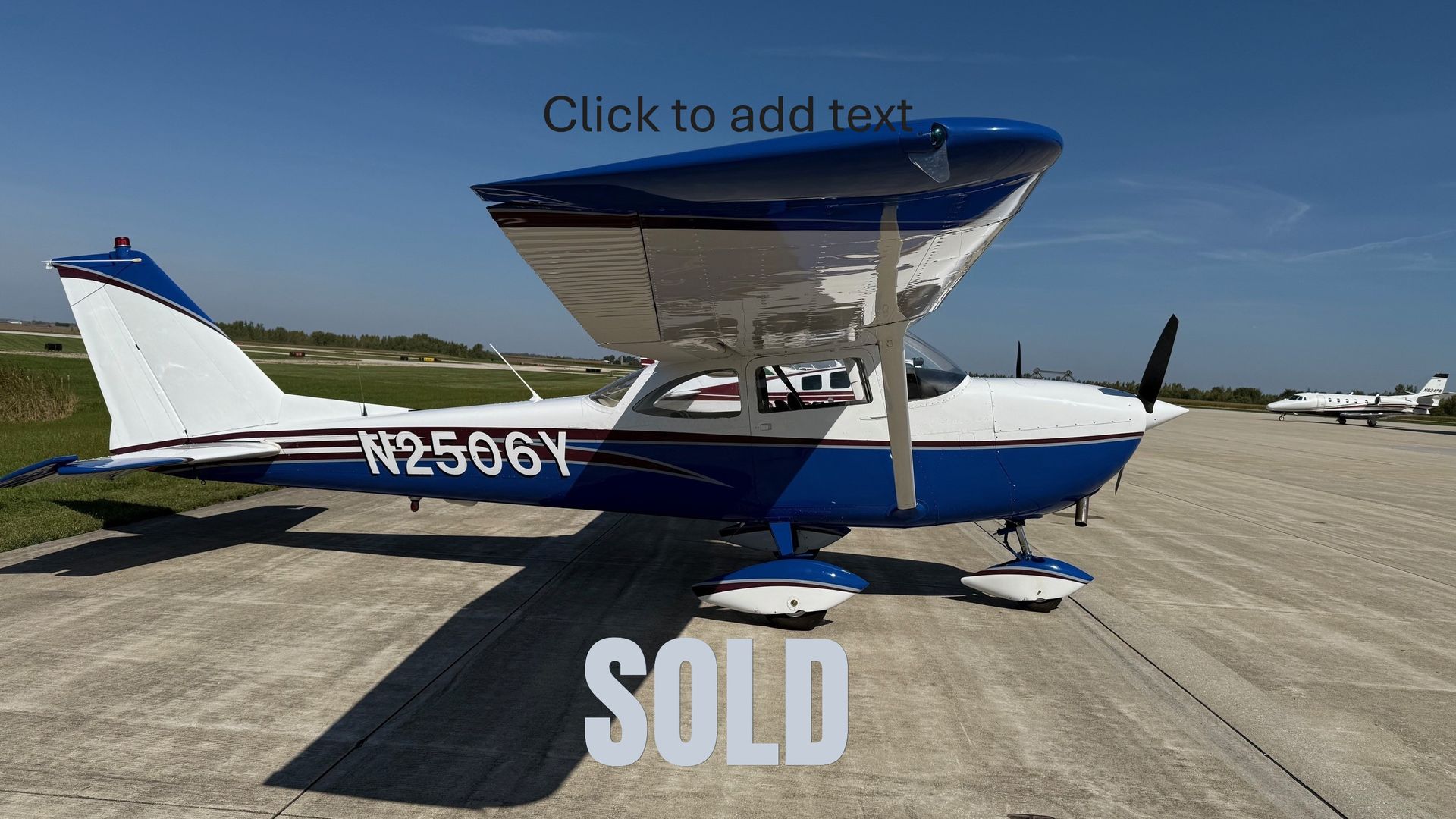 A small red and white plane is parked in front of a building