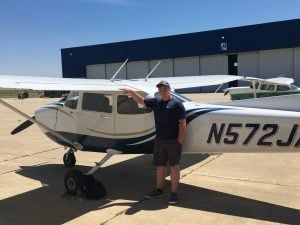 A man is standing in front of a small plane.